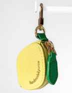 Leather Yellow Lemon  pouch with a green strap and gold hardware on a white background