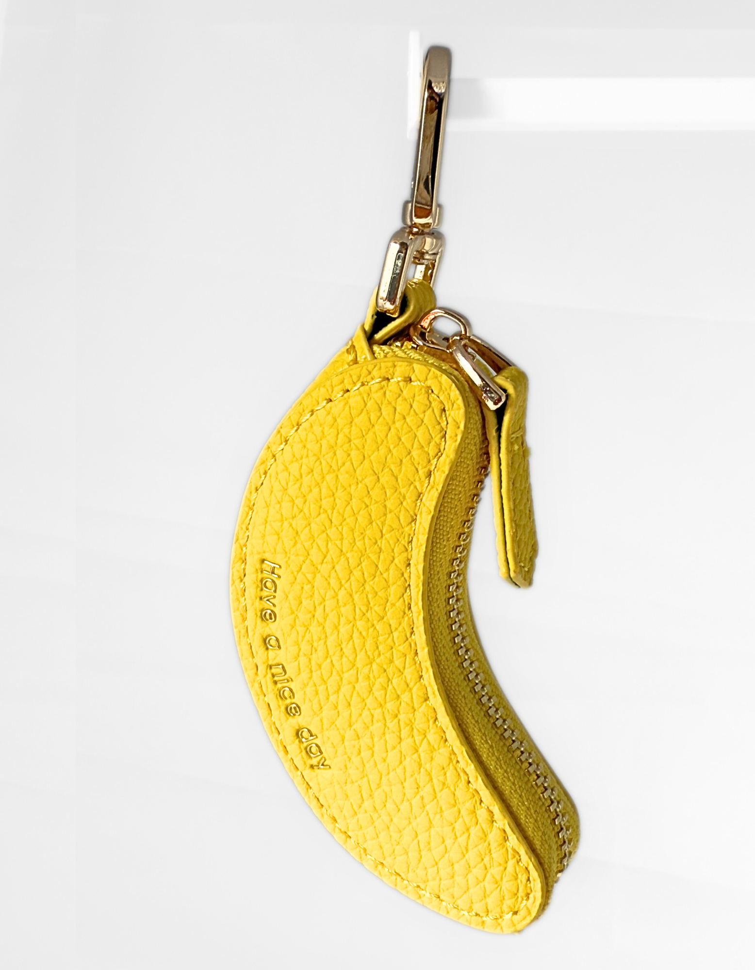 Leather Yellow banana-shaped keychain pouch with a gold zipper on a white background